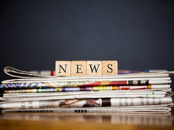 stack of newspapers and article writen with wooden blocks